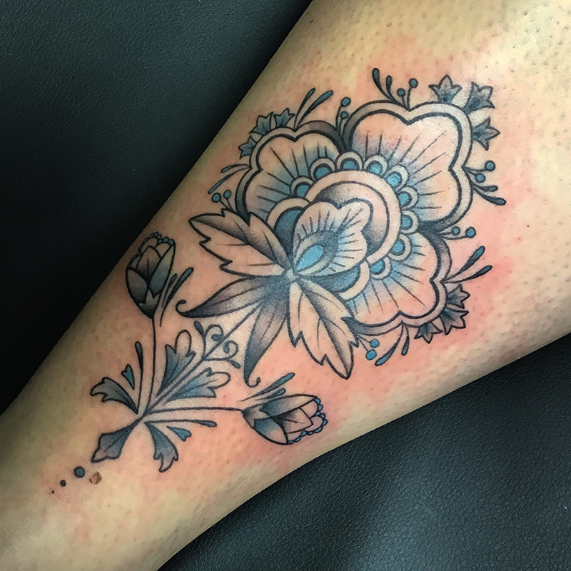 floral blackwork tattoo with blue details